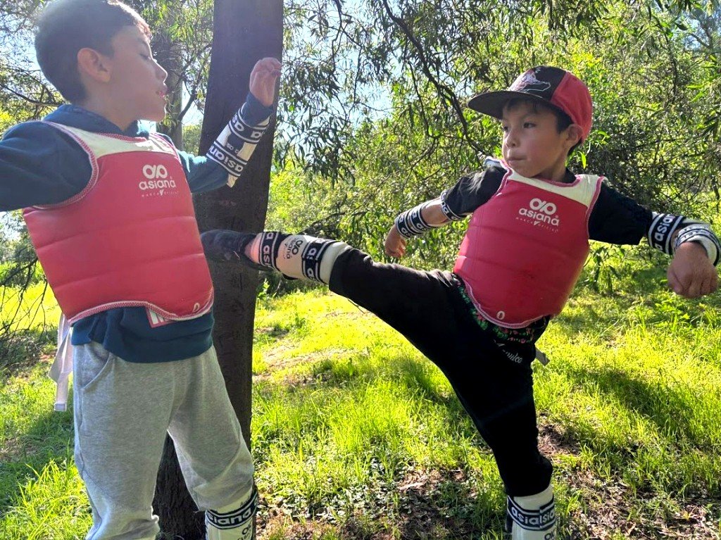 Alumnos infantiles de Jaguares practicando patadas y defensa al aire libre